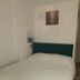 Self Contained Rooms in Central Torquay bedroom with double bed, teal headboard and wall lamp