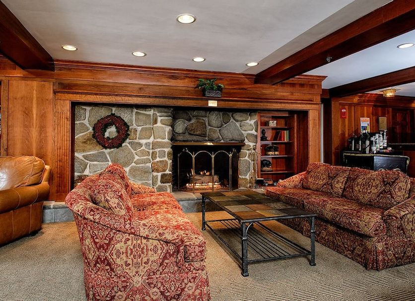 The Valley Inn, an Ascend Collection Hotel in Waterville Valley lounge with stone fireplace and patterned sofas
