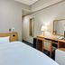 Hotel Route-Inn Aomori Ekimae guest room with bed, desk, chair, lamp and wall mirror in Aomori