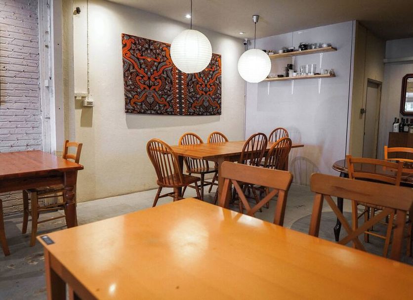 The Goose House Ubon in Ubon Ratchathani dining area with wooden tables, chairs, and pendant lights
