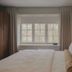 Hotel Belvedere Kingston guest room with king bed, window, and soft neutral curtains