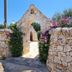 Almapetra Trulli Resort in Locorotondo, stone arch entrance with flowered walls and courtyard path