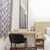 Wisma Rimadi Guest House Jakarta room with bed, desk, chair and patterned curtains