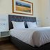 Residencial Lar do Areeiro in Lisbon, a guest room with a double bed, tufted headboard, and window light
