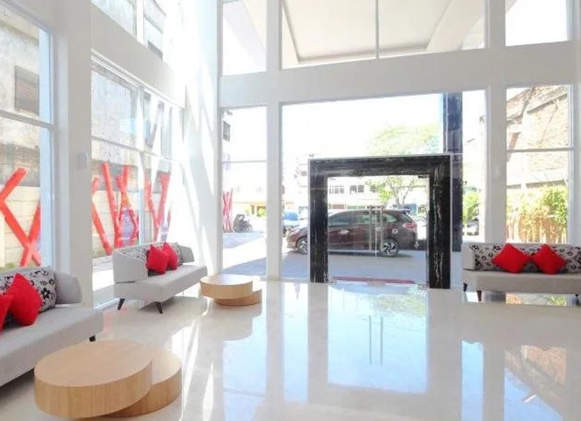Cititel Hotel Dumai lobby in Dumai with white sofas, red cushions, and tall glass windows
