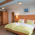 Hotel Mingarden Düsseldorf guest room with twin beds, wood accents, built-in closet and bedside lamps