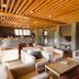 Reserva del Saja Hotel & Spa lounge with armchairs, stone fireplace and wood-slat ceiling in Renedo de Cabuérniga