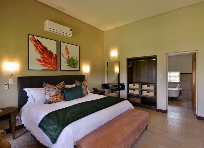 African Hills Safari Lodge & Spa room in Magaliesburg with king bed, bathroom entrance and warm lighting