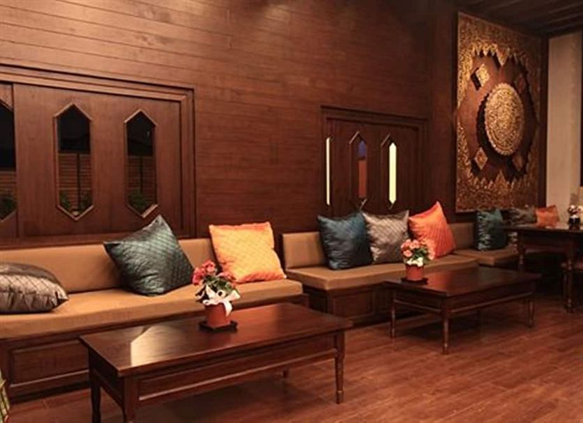 Baan Ratchiangsaen in Chiang Mai lounge with wooden seating, coffee tables, and decorative wall art