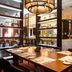 Hilton Kyiv restaurant with modern dining tables, backlit shelves and chandelier-style lighting