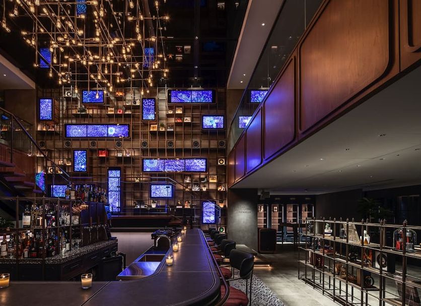 The Lively Fukuoka Hakata in Fukuoka features a dramatic bar with hanging blue screens and mirrored lighting.