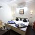 Hotel Avtar in Ludhiāna guest room with double bed, two chairs, and bedside lamps