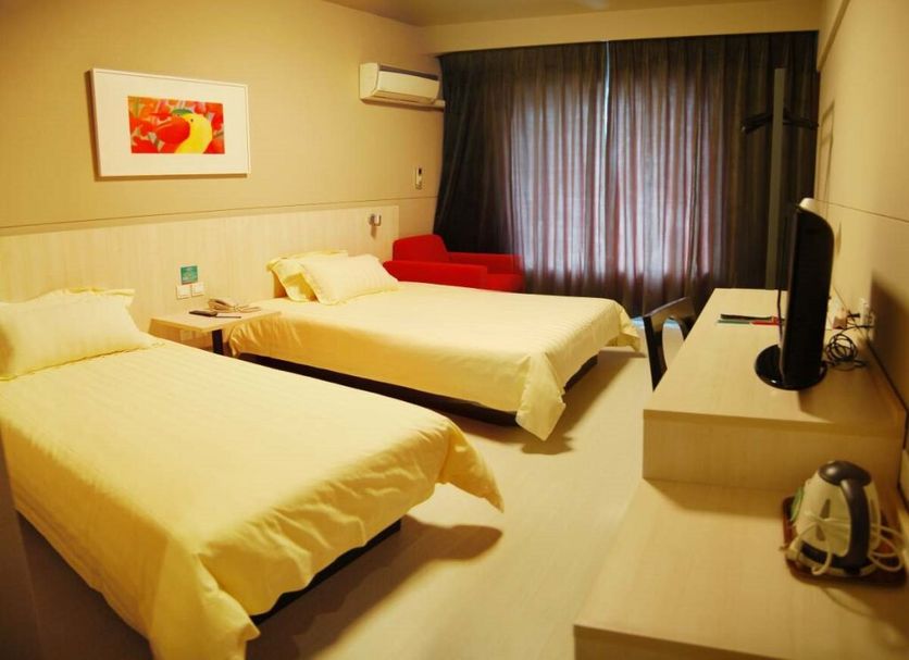 Jinjiang Inn Tianjin Zhongshan Road guest room with two beds, TV, and red chair in Tianjin