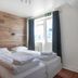 Stay Apartments Einholt Reykjavik bedroom with twin beds, wood accent wall, and window with curtains
