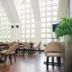 Isabella Boutique Hotel in San Pedro Sula dining area with tall grid windows and beige chairs