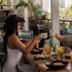 Guests toast breakfast at Hotel Barahona Cartagena in Cartagena's airy restaurant with tropical plants.