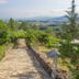 Hotel Rural Casa de Samaioes in Chaves: stone path through lush gardens with valley and mountain views