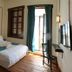 Olea Leya Hotel in Ayvalik bedroom with double bed, wood floors, wall-mounted TV and balcony doors
