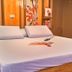 Hotel Sogo Quezon Avenue in Manila guest room with large bed, floral wall art, and warm wood paneling