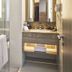 Hotel Grandhika Iskandarsyah Jakarta bathroom with vanity, mirror, towels and glass shower