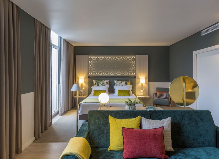 Hotel Estrela de Fatima room in Fátima with four-poster bed, sofa, large window and gold chair