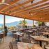 Roda Beach Resort & Spa in Roda with a shaded terrace dining area overlooking the pool and sea