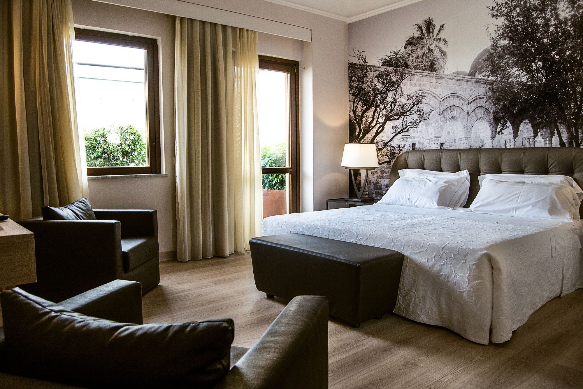 Hotel Federico II Central Palace Palermo guest room with king bed, armchairs, and balcony doors