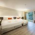 Le Tada Residence Bangkok guest room with twin beds, window seat and city view