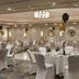 Portsmouth Marriott Hotel in Portsmouth banquet hall with round tables, white chair covers, and black and gold balloons