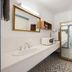 Castle Motel Bairnsdale bathroom with sink, mirror, and wardrobe-style closet with bed storage
