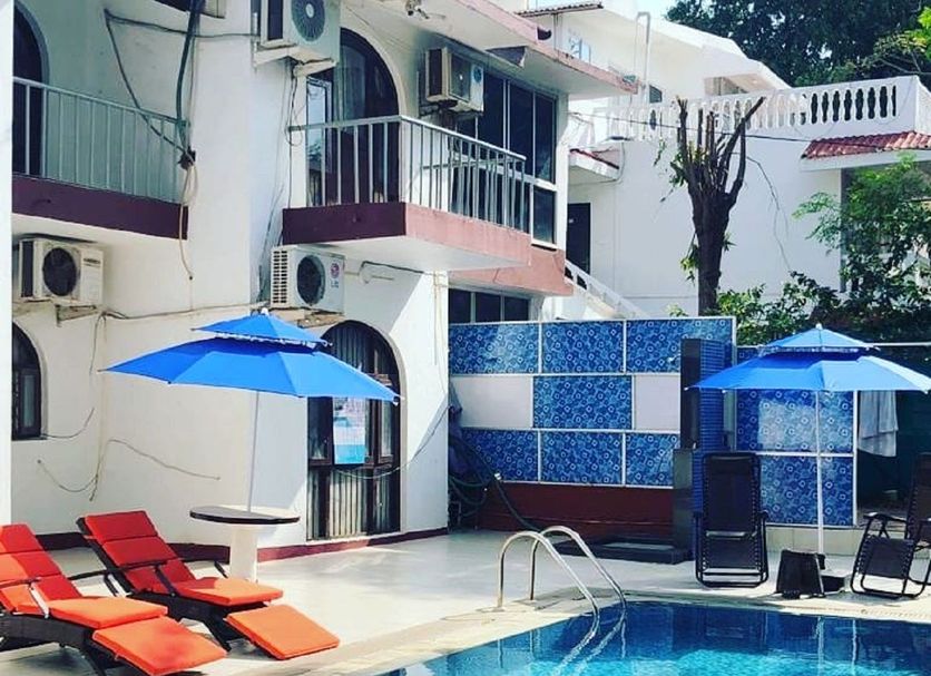 Athi Resorts in Bogmalo with outdoor pool, blue umbrellas, and sun loungers