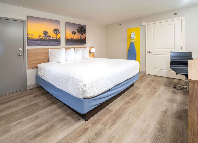 Days Inn by Wyndham Atlanta Stone Mountain guest room with king bed, desk, and sunset wall art
