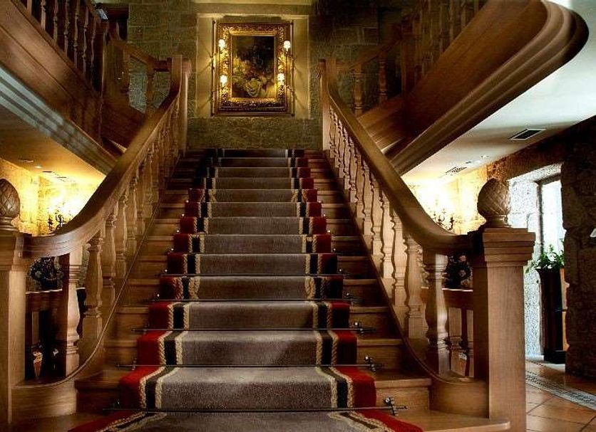 Pazo Los Escudos Hotel Spa & Resort in Vigo grand staircase with ornate wood banisters and framed artwork