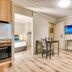 Il Mondo Boutique Hotel Brisbane suite with kitchenette, dining area, wall TV, and bedroom view