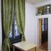 Chambre d'hôtes Au Nid du Thil room in Beauvais with green curtains, wall TV, desk, and window