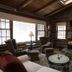 Chalet of Canandaigua lounge with stone fireplace, wood ceiling, large windows and rustic seating