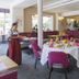 Eden Hotel in Bad Krozingen dining room with set tables, magenta chairs and upholstered banquettes