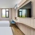 Hanting Hotel Wuxi Railway Station Guangrui Road room with two beds, desk, wall TV and window