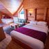 Natyral Razma Resort room in Razem with wood-paneled walls, bed, sofa, and loft-style ceiling