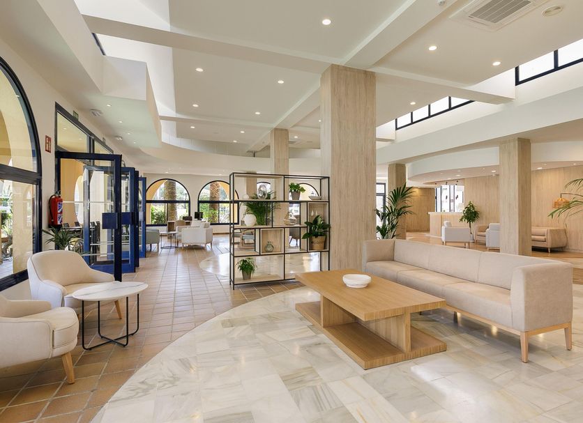 Sol Sancti Petri in Chiclana de la Frontera lobby with beige seating, coffee table, and skylit atrium
