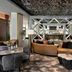The Westin Anaheim Resort lobby with curved tan sofa, geometric mirrored partition, and patterned ceiling in Anaheim
