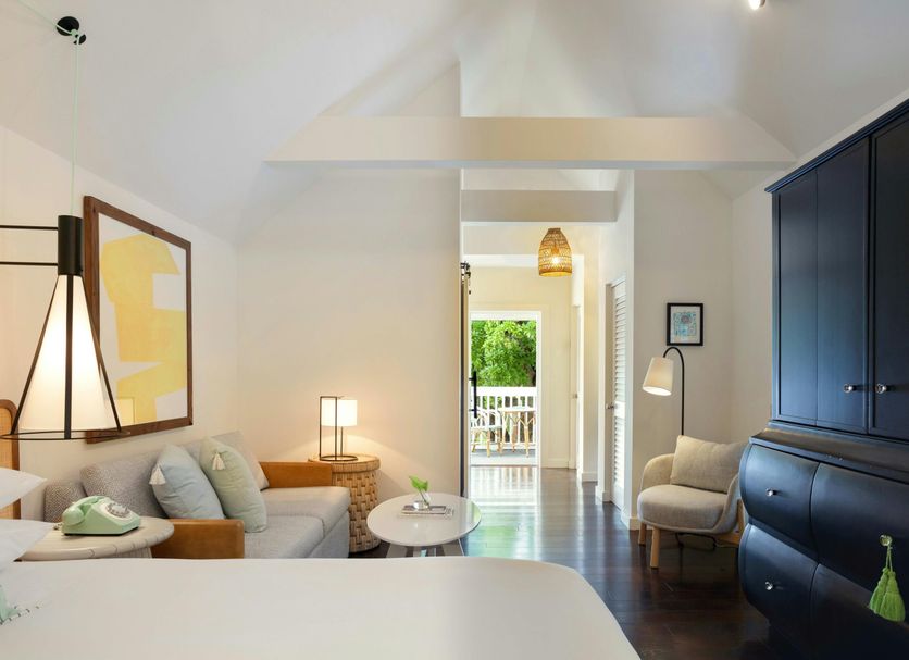 Winslow's Bungalows in Key West guest room with vaulted ceiling, sitting area, and view to a balcony.