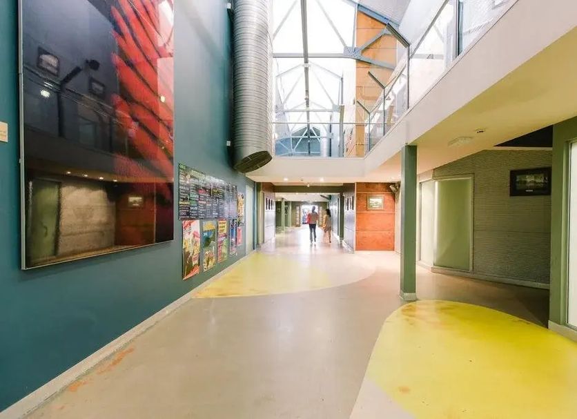 Global Backpackers Cairns Central lobby corridor with skylit atrium and colorful wall art in Cairns