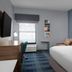 Hampton Inn Russellville guest room with king bed, desk, TV, and window air unit