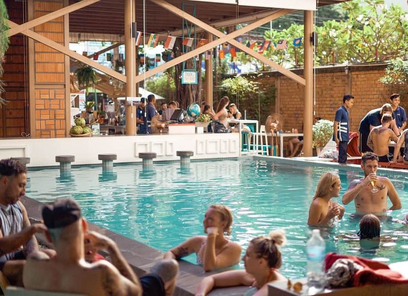 Lub d Siem Reap pool with guests relaxing and swimming in a lively outdoor setting