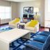 Sheraton Fort Worth Downtown Hotel guest room with sofa, chairs, desk, TV and blue geometric rug