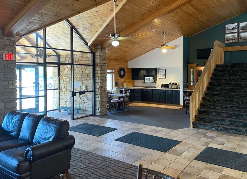 Motel 6 Norway MI lobby with vaulted wood ceiling, staircase and seating area in Norway