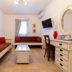 Plaza Beach Hotel in Plaka living area with seating, desk, wall TV, and coffee table