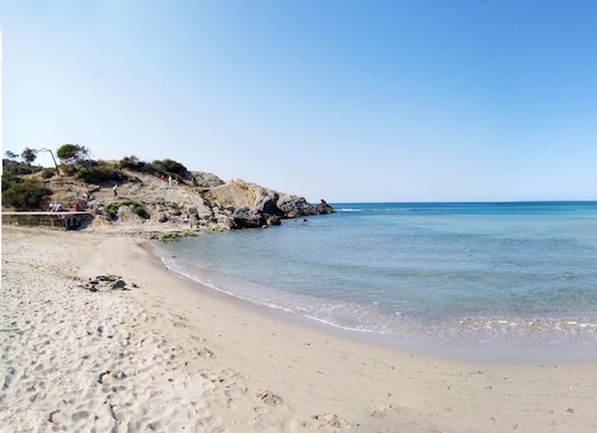 BQ Maria Dolores in Peguera with a sandy beach and calm blue bay under a clear sky