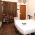 La Villa Creole, Pondicherry: simple guest room with bed, desk and curtained window